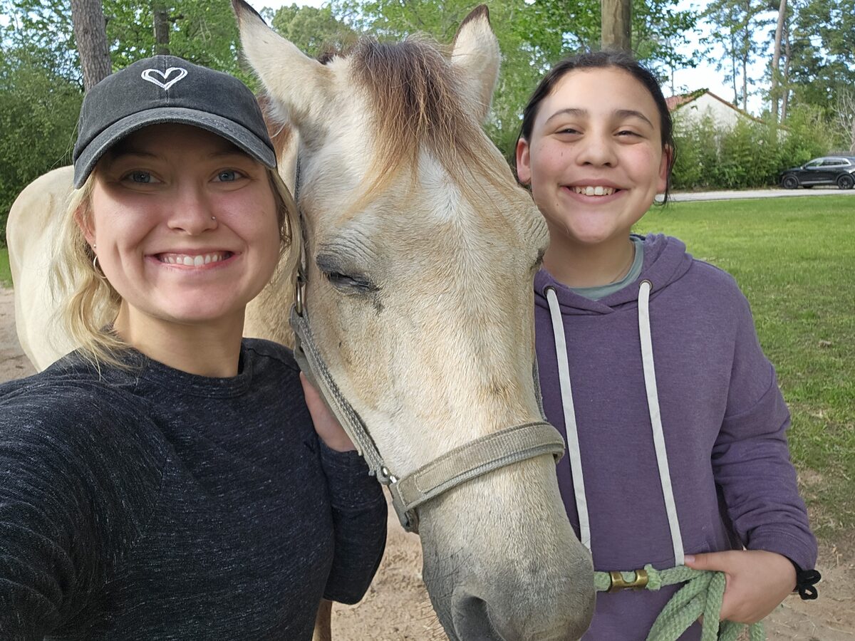 Meg with a young camper and one of the horses