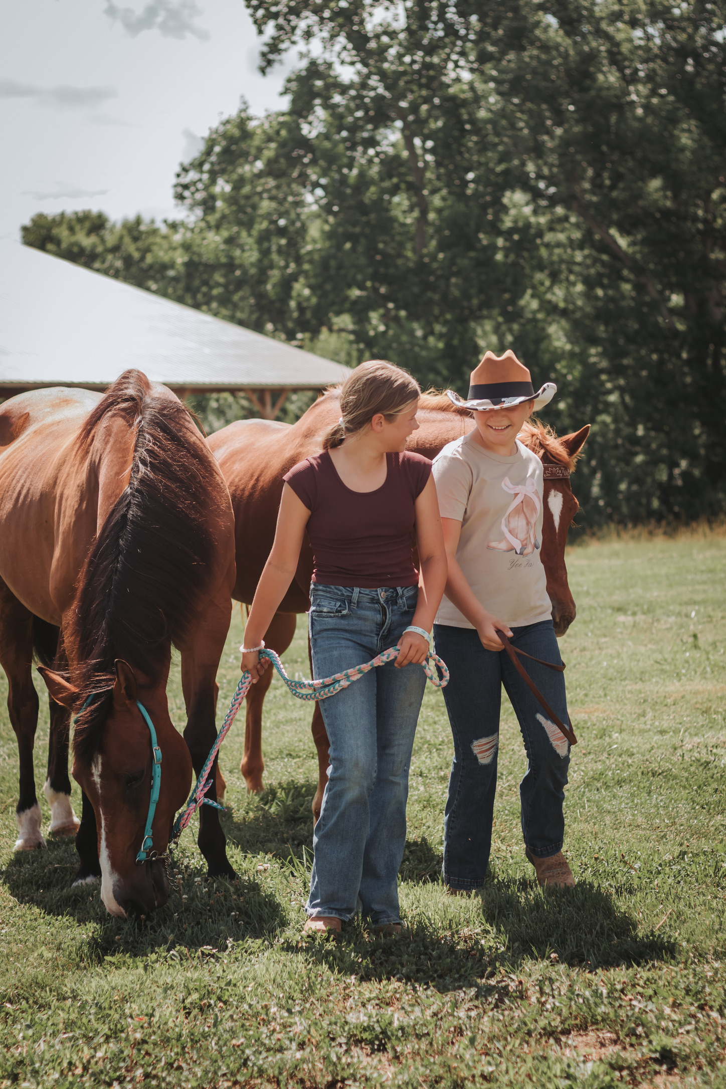 Two young riders walking horses in from the field