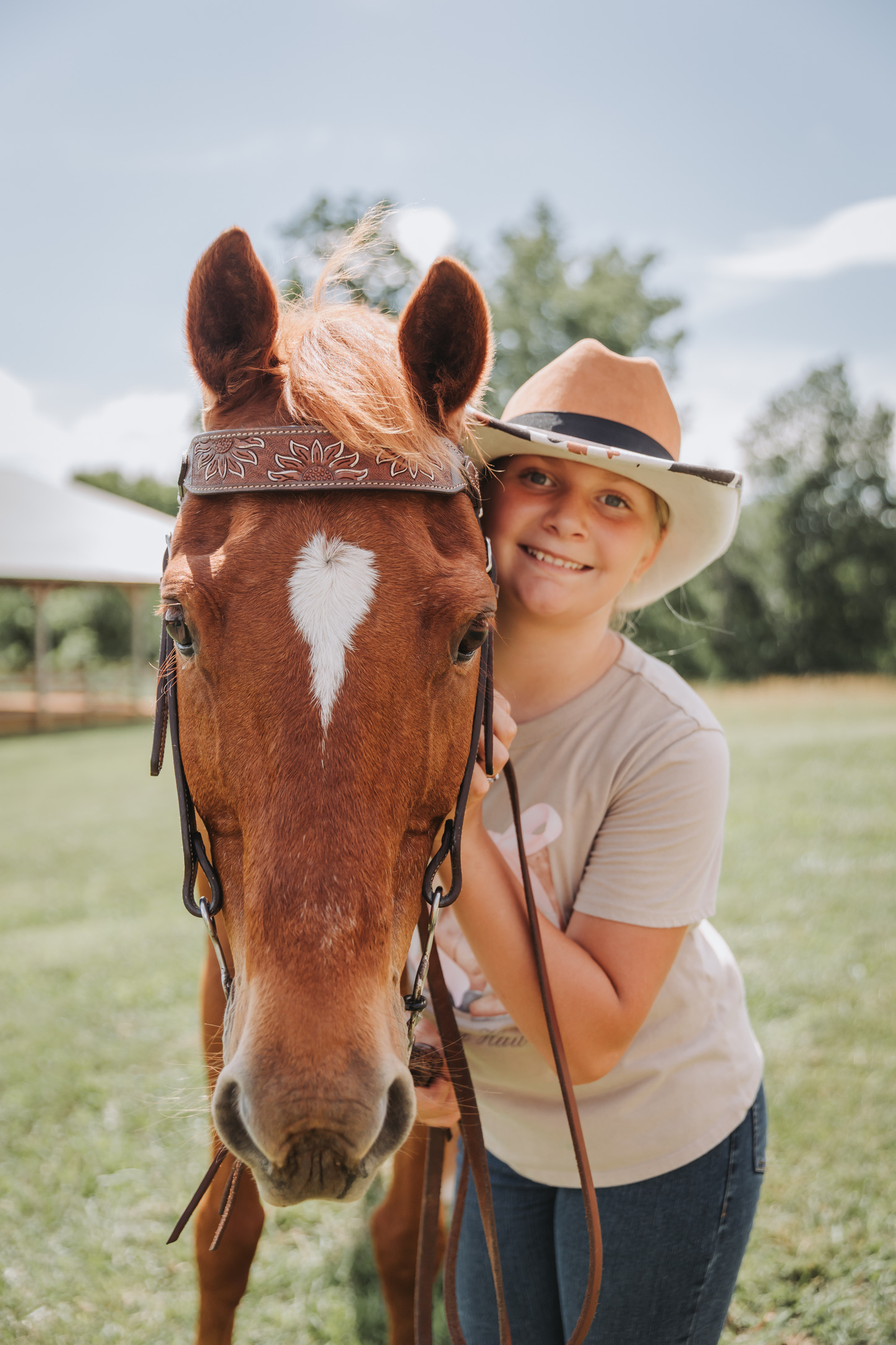 A young rider in a cowboy hat with her horse