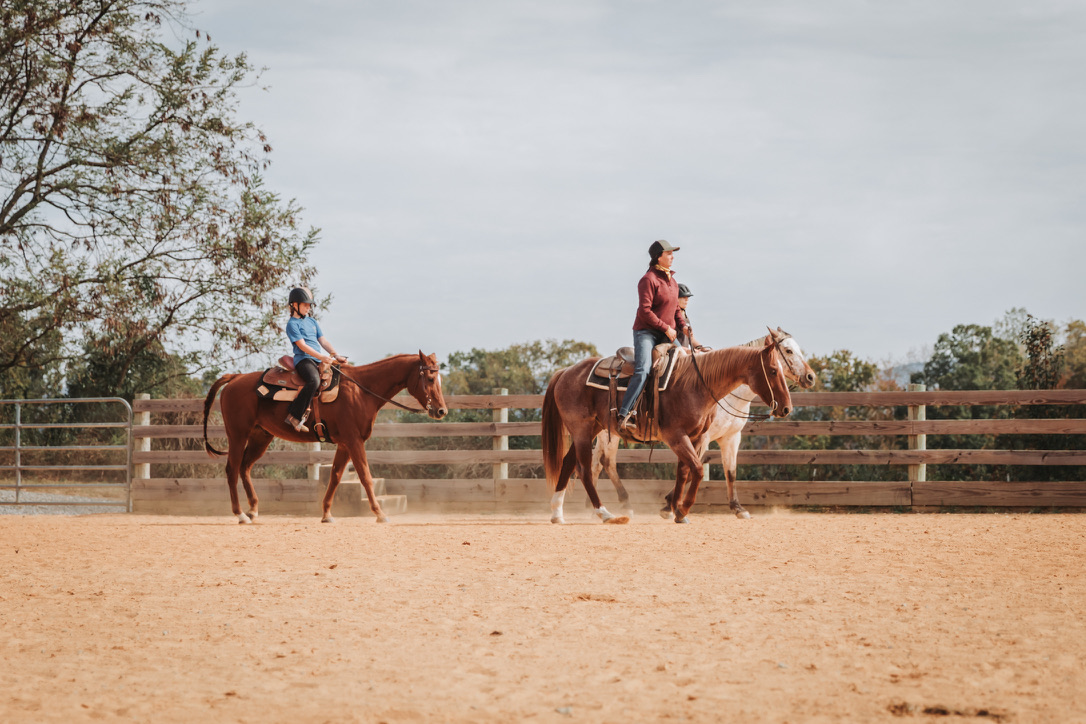 An instructor coaching riders in the arena