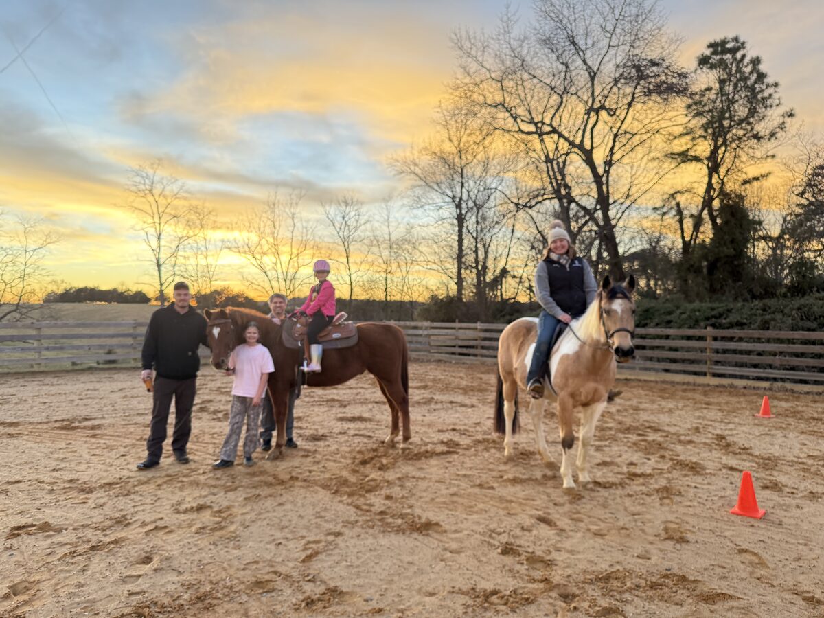 A family lesson in the arena at golden hour